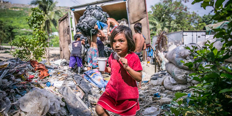 A poor Payatas child walking among the Garbage